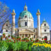Church in Vienna with blue sky and flowers in the foreground